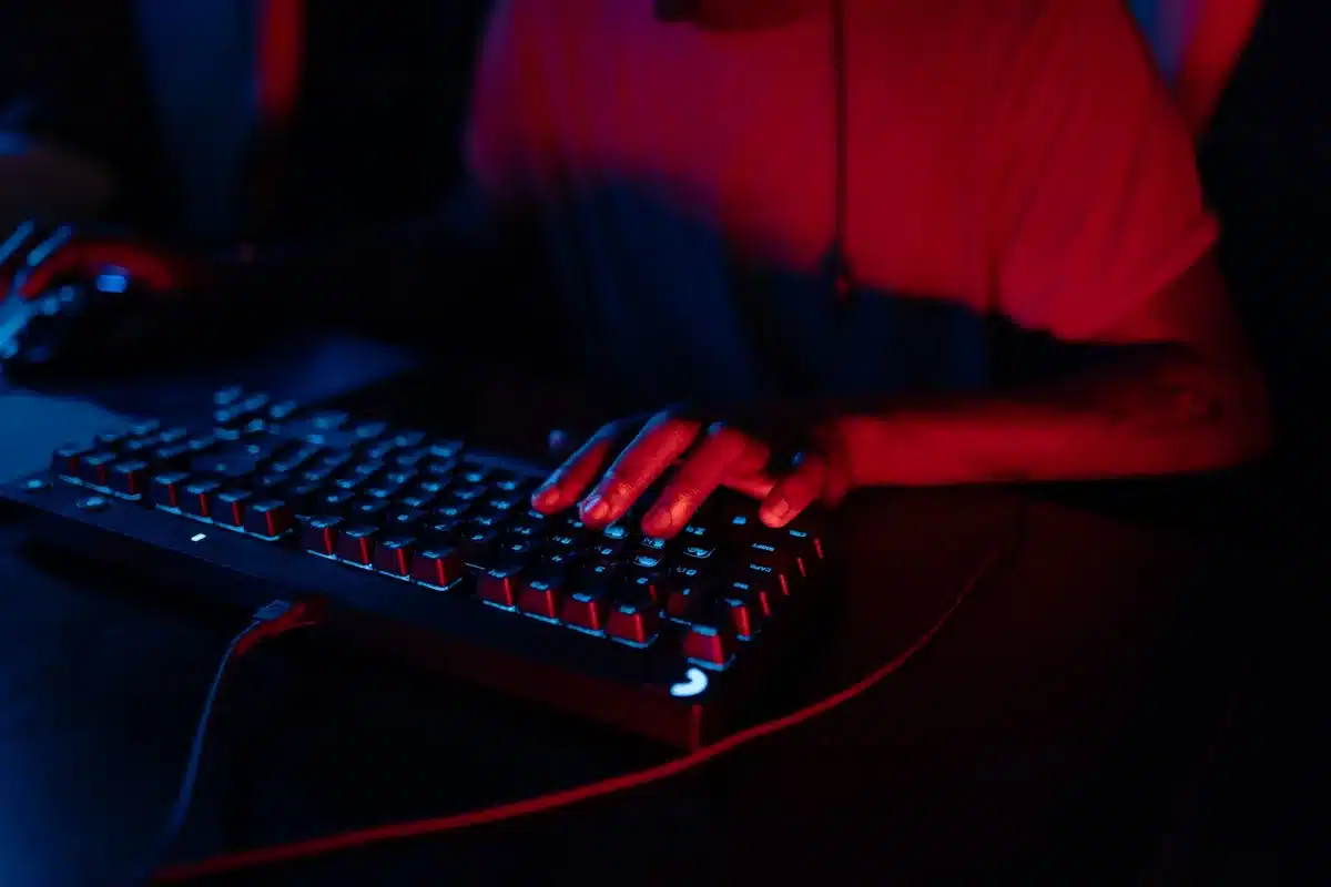Manos escribiendo en un teclado con respuesta precisa durante sesi&oacute;n de juego