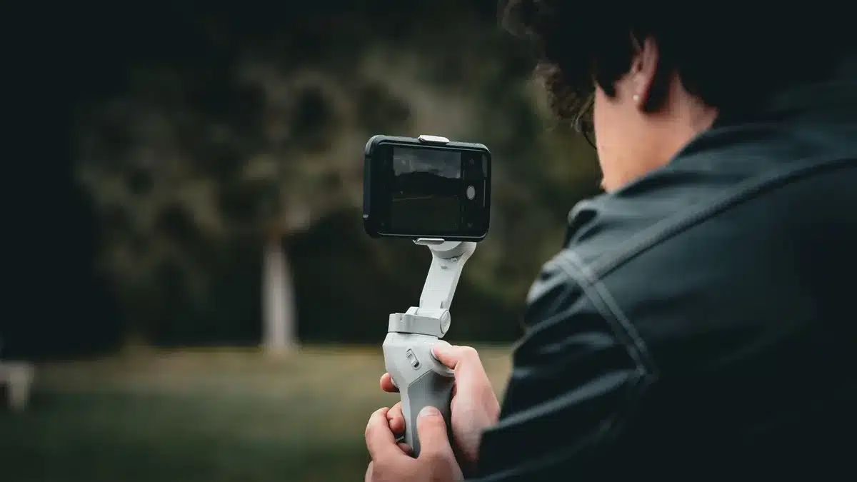 Smartphone con brazo gimbal integrado estabilizando la c&aacute;mara durante grabaci&oacute;n
