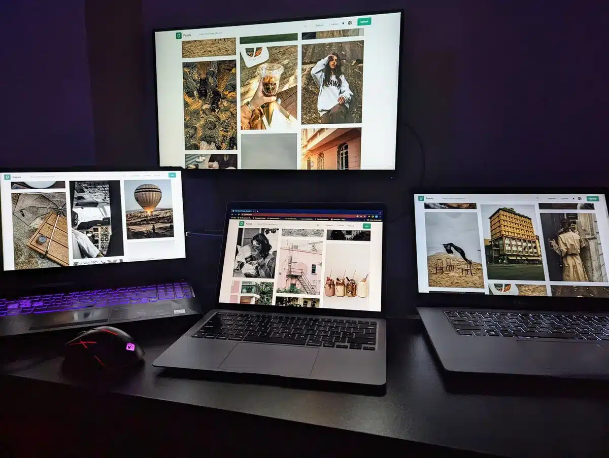 A sleek gaming laptop with a glowing OLED screen displaying vibrant game visuals, metallic finish catching studio light, closed at an angle on a dark desk with RGB peripherals nearby&mdash;power and precision.