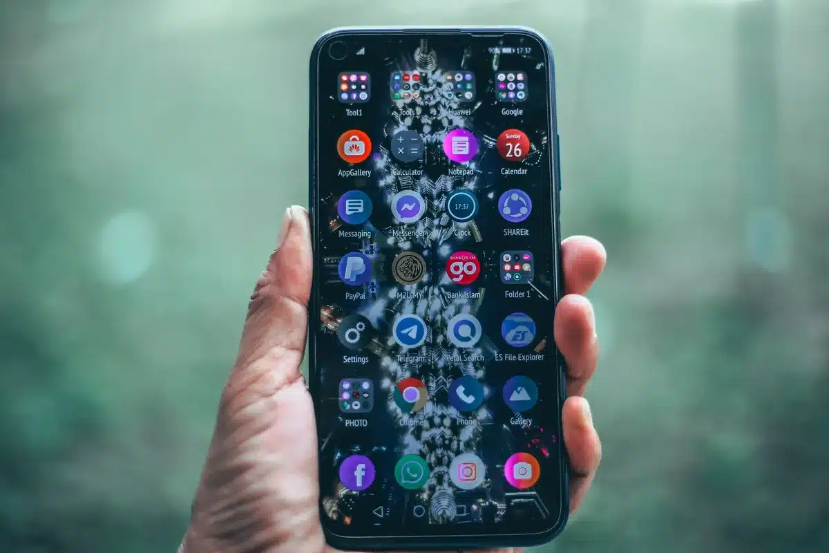 Budget smartphone with large display and rounded edges in neutral color, front and back visible, minimalist composition highlighting screen size