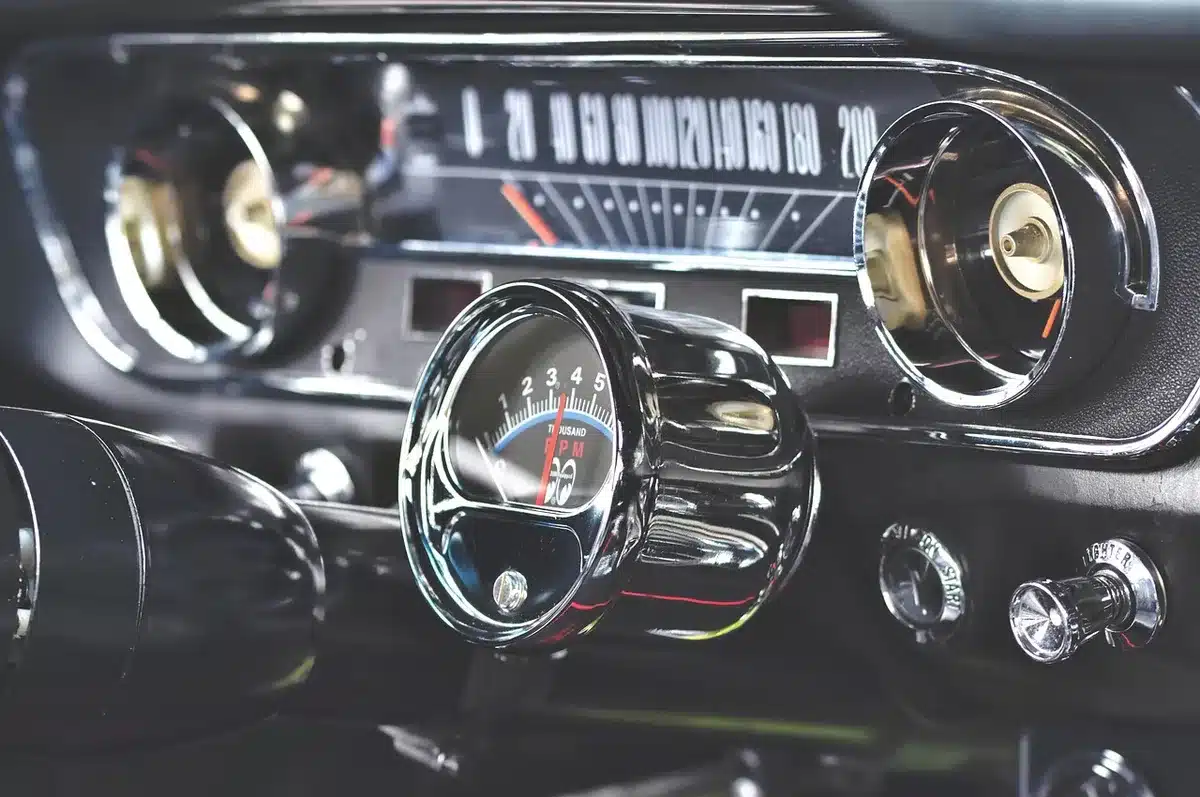Dashboard of a car with a connected smartphone showing CarPlay interface, steering wheel controls visible, sunlight streaming through windshield