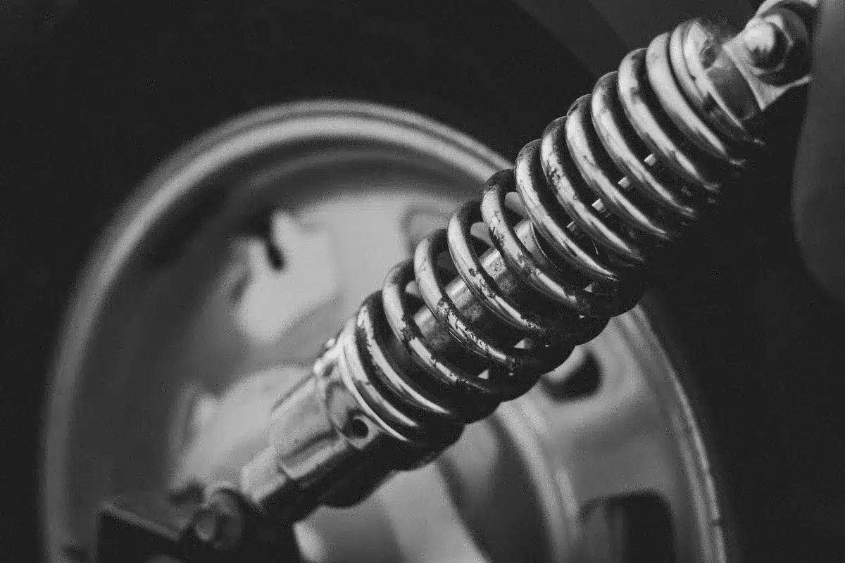 Close-up of dual disc brake system and suspension components, metallic parts catching light, technical detail shot showing engineering quality, shallow depth of field