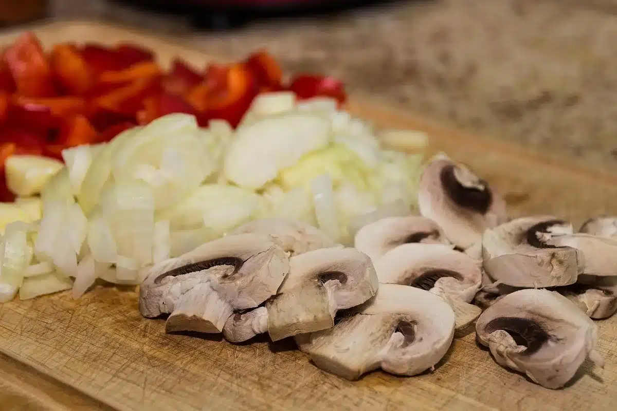 Peras y manzanas cortadas en cubos pequeños sobre tabla de cocina