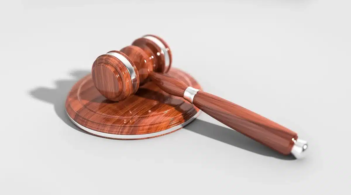 Escena de tribunal con documentos y gavel, representando conflicto legal sobre propiedad de software