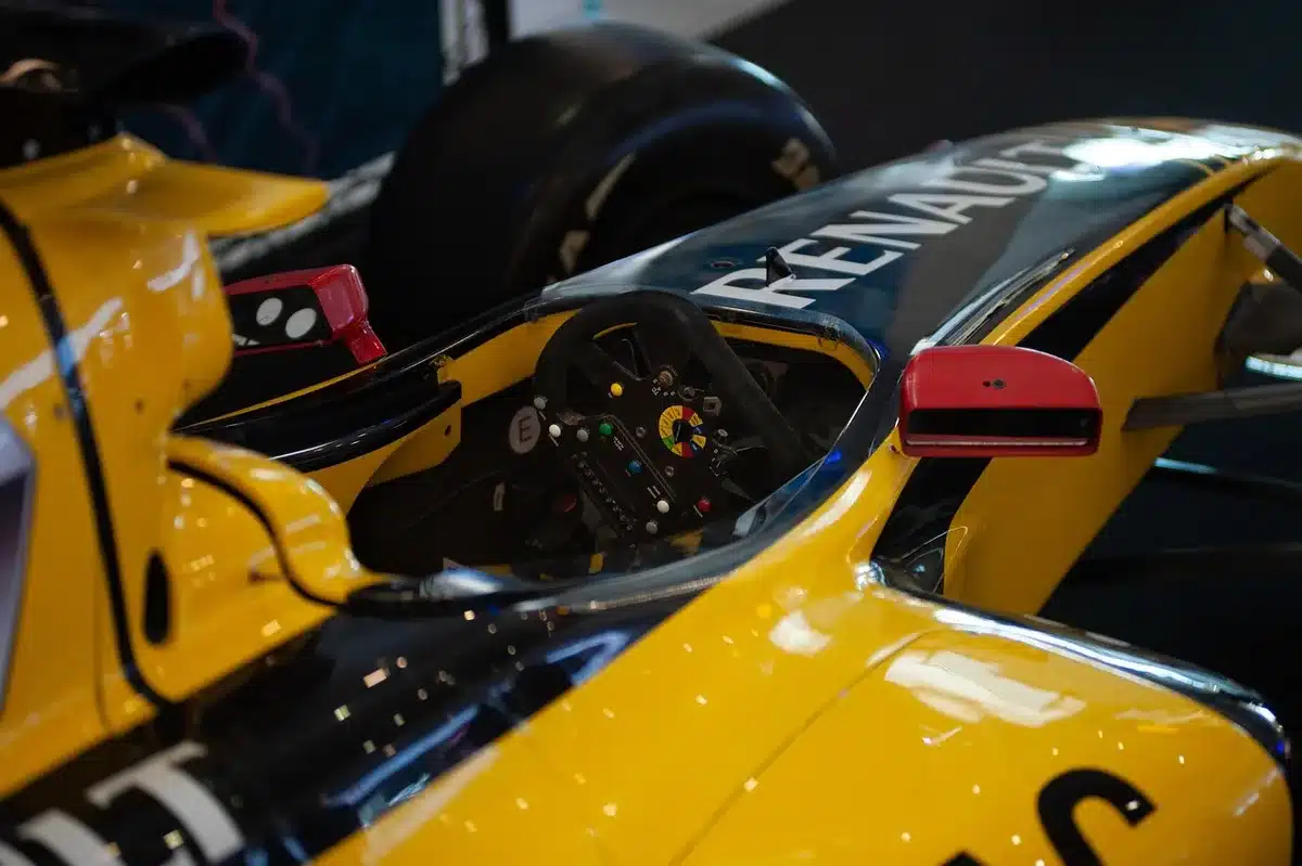 A detailed close-up of racing wheel controls and dashboard instruments, showing the precision interface between driver and machine