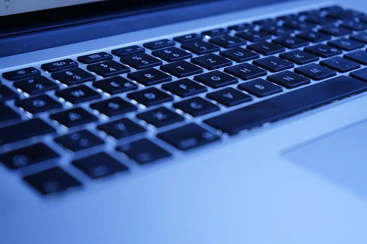 Close-up of the MacBook Air 2020's keyboard and trackpad area, showing the refined input devices with soft lighting that highlights the precision engineering and the slim profile characteristic of the Intel-era design.