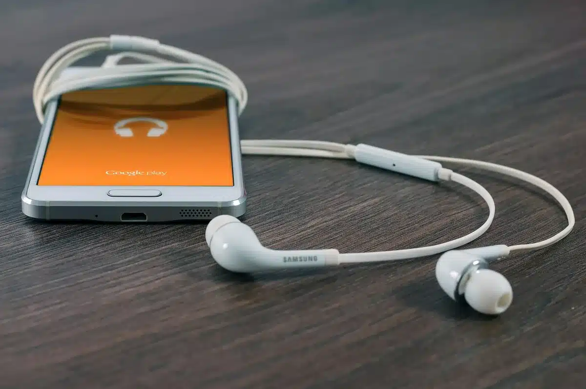 Smartphone placed on a modern desk surrounded by wireless charging accessories and tech gadgets, soft ambient lighting, minimalist composition