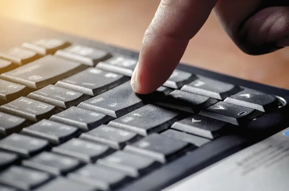 Mano usando teclas f&iacute;sicas en un tel&eacute;fono para escribir sin mirar