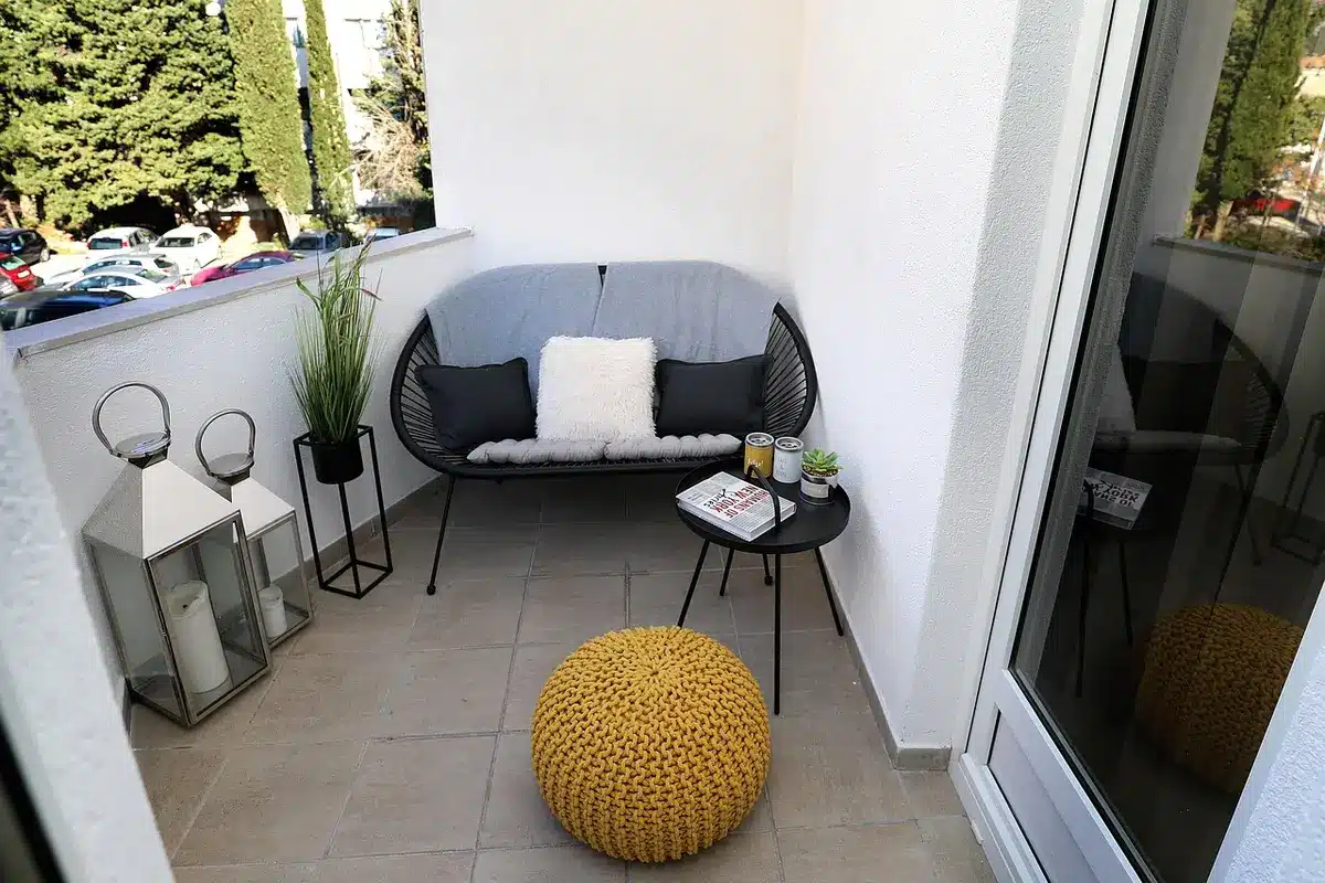 Toldo con brazos telescópicos instalado en un pequeño balcón urbano