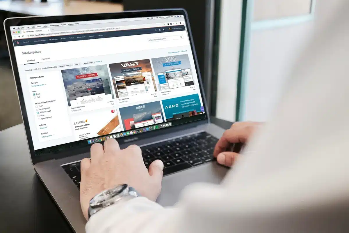 Anonymous shopper inspecting a generic gaming laptop on a display table, hands hovering over keyboard, store interior blurred