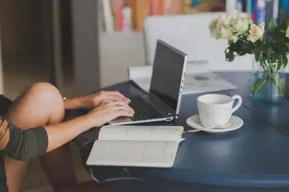 Portátil ultraligero sobre mesa de viaje junto a una taza, en ambiente luminoso