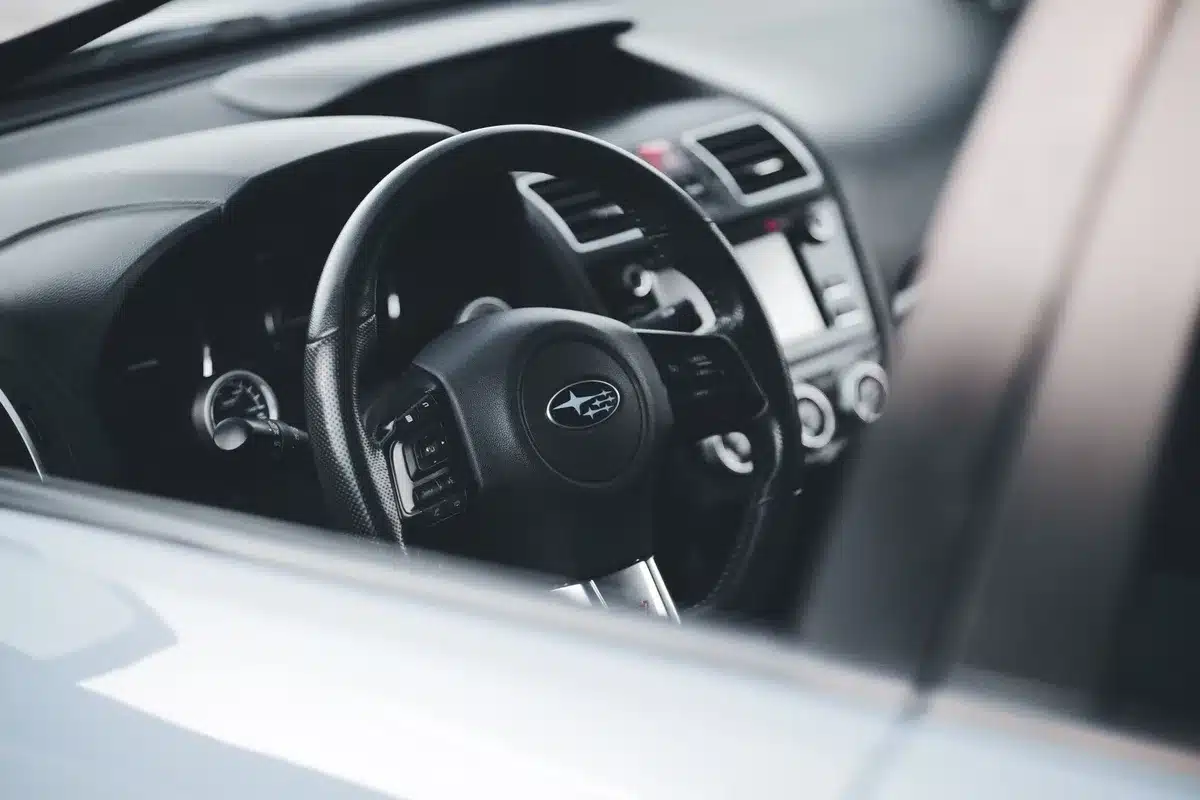 A generic car center console with an unplugged USB cable and a smartphone nearby on the passenger seat, no logos, anonymous interior