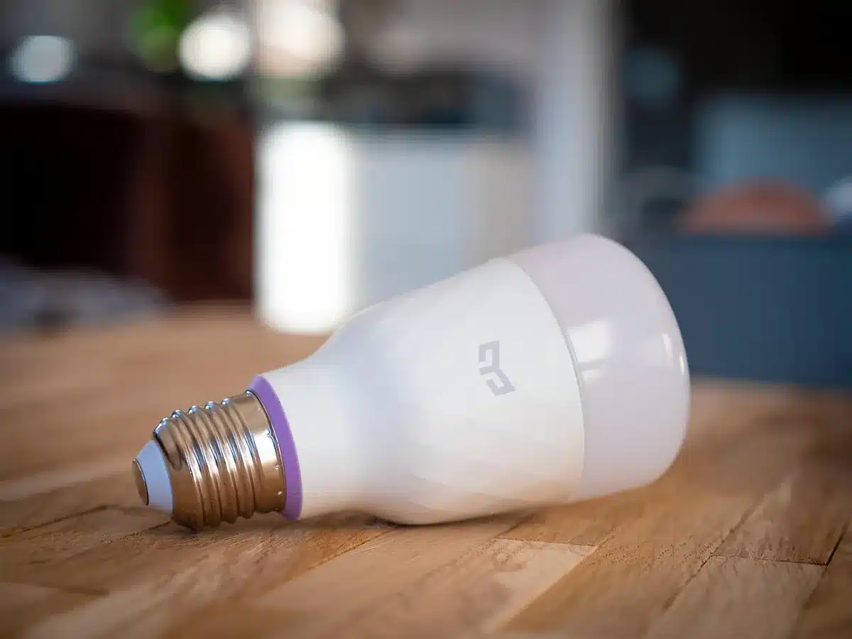 anonymous hands unboxing a small unbranded smart speaker on a table