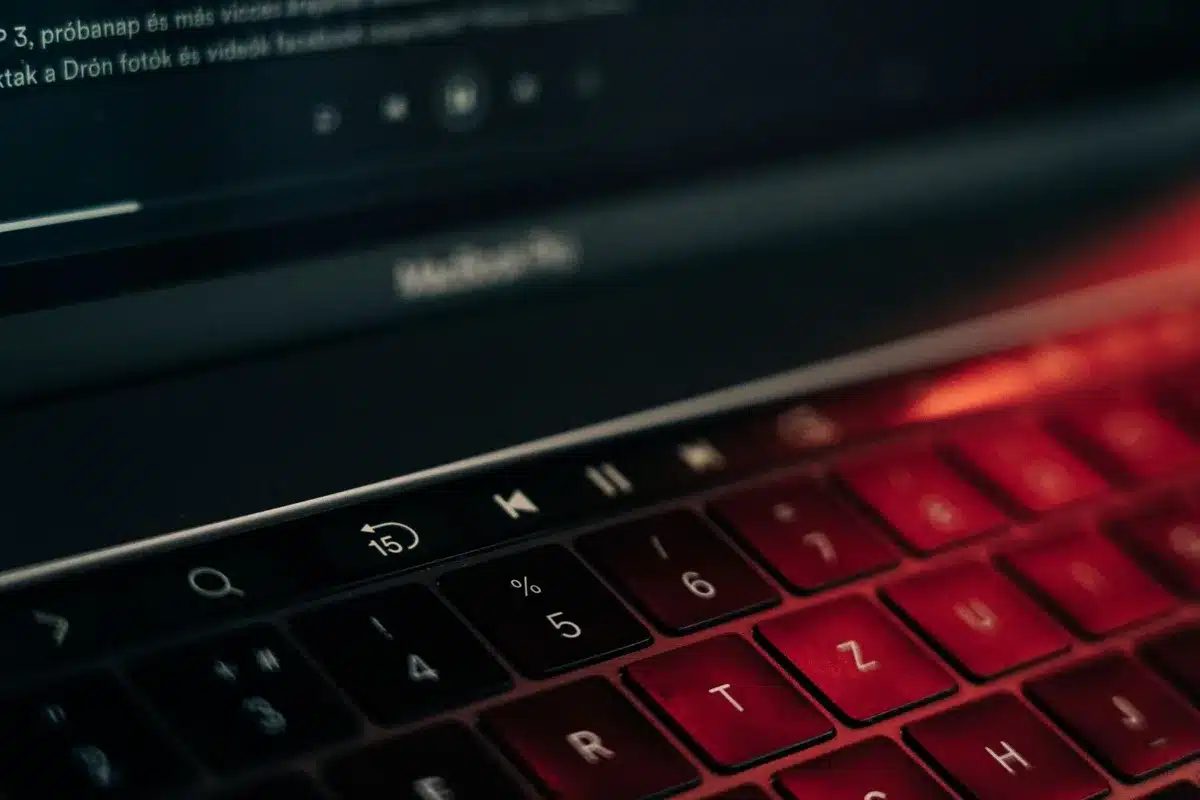 Unbranded laptop closed on a desk with a subtle glowing circuit pattern reflecting on the lid, small anonymous cables nearby