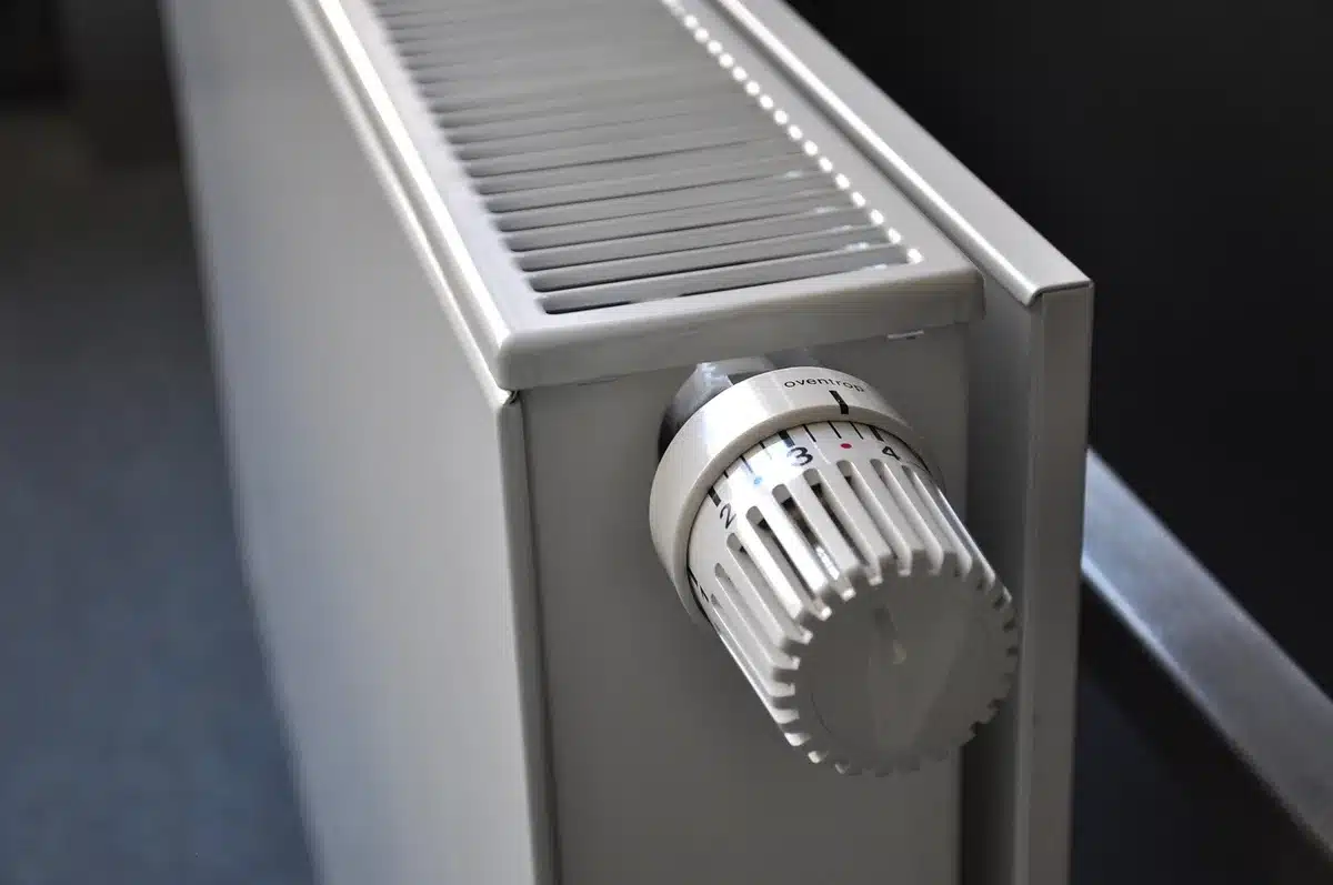 Radiador en una habitación y factura de energía sobre la mesa
