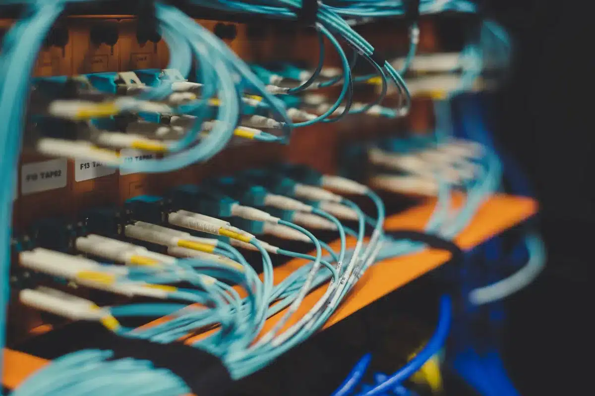 Close-up of a modern server rack with blurred blinking LEDs, anonymous cables and a generic hard drive bay visible — evokes migration and data movement