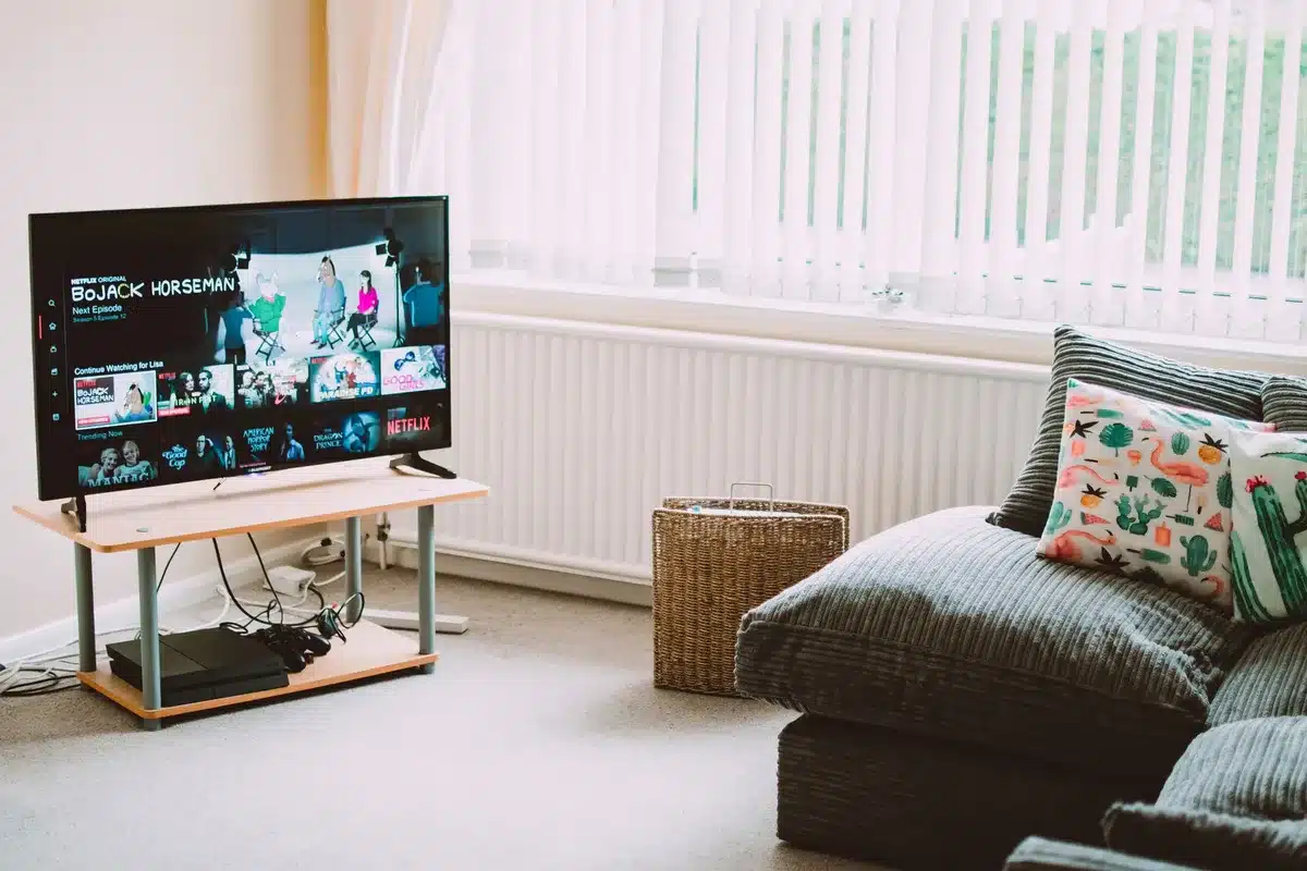 Empty living room with a TV showing a paused family comedy poster, popcorn bowl on a coffee table