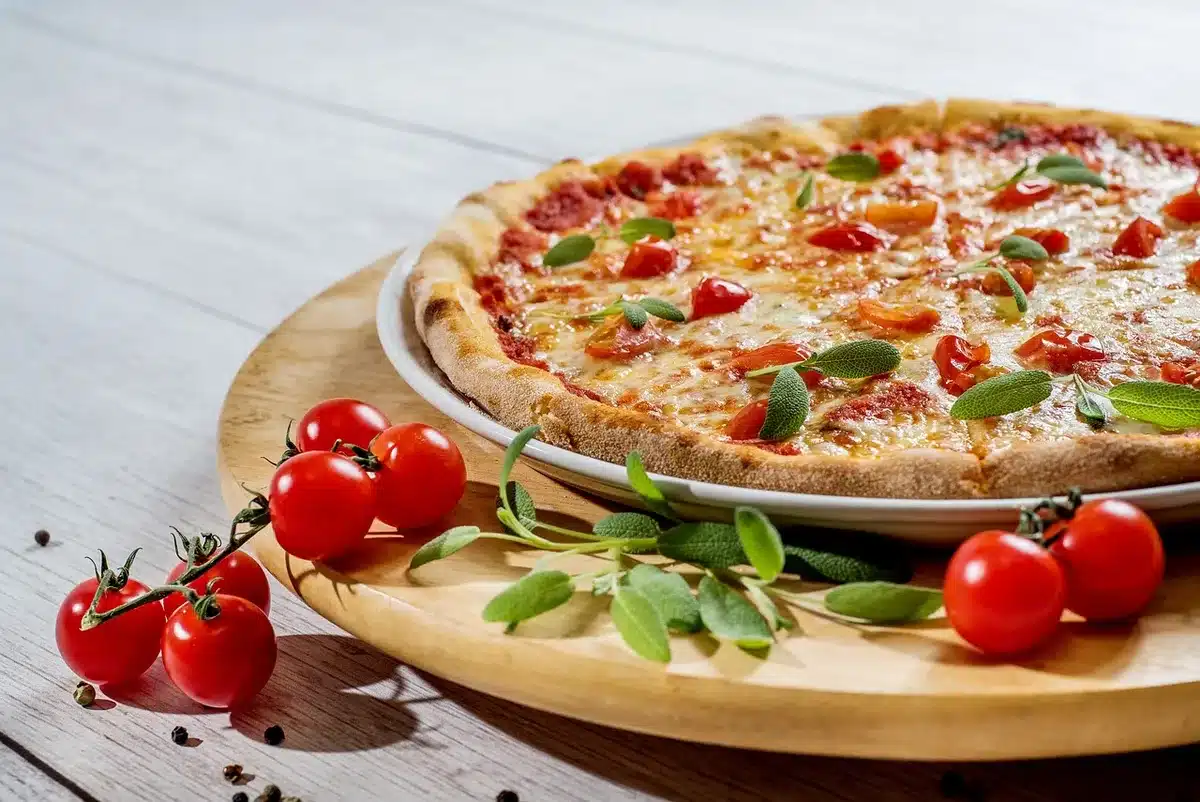 Variedad de quesos y pizza antes de hornear