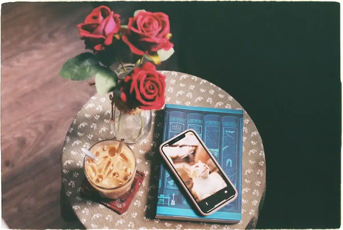 An anonymous unbranded smartphone on a table with its screen on showing a colorful home screen glow; no logos or text visible, bright indoor setting